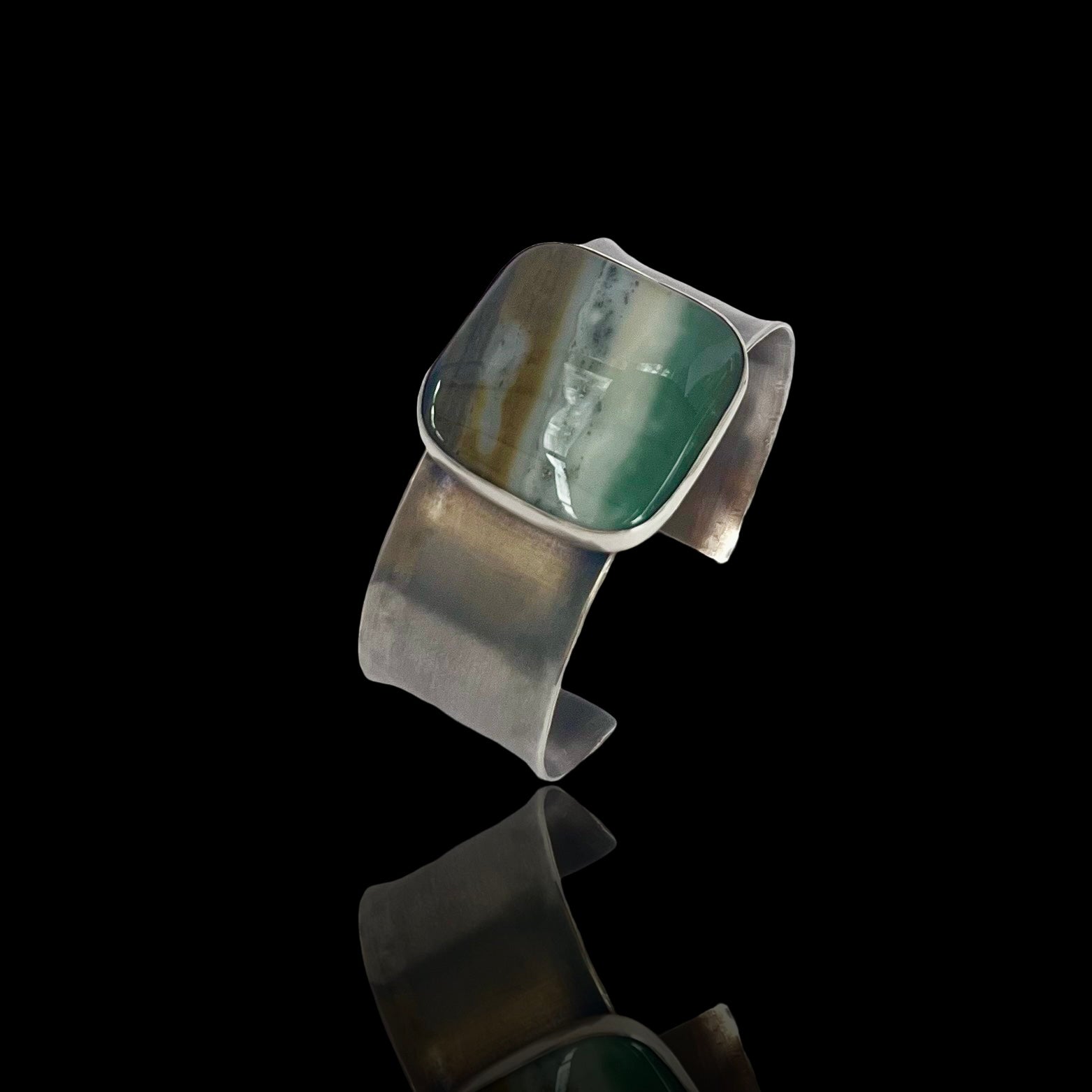 A slightly reticulated sterline cuff with a large square ocean wave jasper.