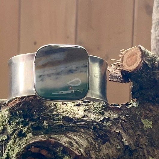 A slightly reticulated sterline cuff with a large square ocean wave jasper.